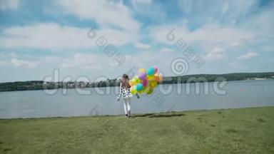 漂亮女孩带着五颜六色的气球跑到河湾
