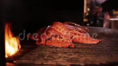 厨师把大块的排骨放在烤架上。 肉在一个大烤架里炒。 烤火的排骨