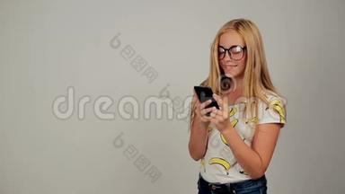 可爱的年轻女子在录音室戴着眼镜在手机上发短信
