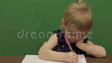 女孩在桌子边画画。 教育进程。 那个女孩有个好主意。 快乐的三岁女孩。 可爱的女孩微笑