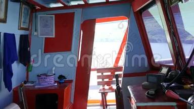 泰国亚洲渔船驾驶舱。 在阳光明媚的渔船上装有轮子和导航设备的空座舱