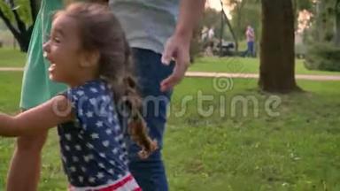 年轻<strong>的</strong>一家人夏天在公园散步，女儿跑步，捕捉泡泡，<strong>童年的</strong>概念