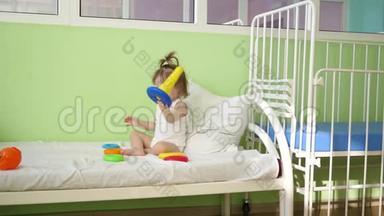 婴儿在床上玩金字塔和彩色戒指。 学前和幼儿园儿童的教育玩具.. 儿童玩具
