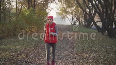 早晨在浓雾中在城市公园慢跑一位年轻女子。 日出。 任何天气概念下的健康生活方式