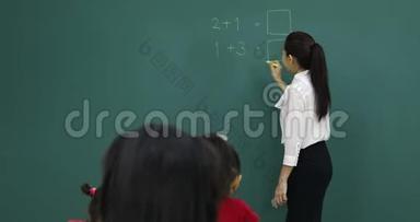 亚洲老师在绿板上写数学题..