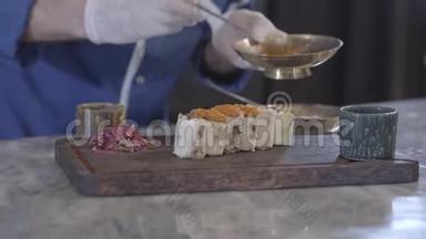 戴着橡胶手套的人用勺子在拉瓦什皮塔卷里给切好的露拉烤肉串上配料。厨师烹调美味