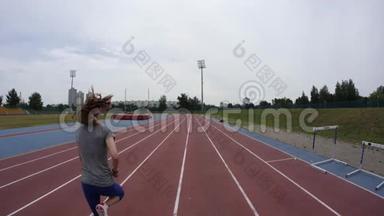 一位年轻的<strong>运动</strong>女子在UHD宽镜头<strong>摄像机</strong>上以4K慢动作在城市田径跑道上奔跑