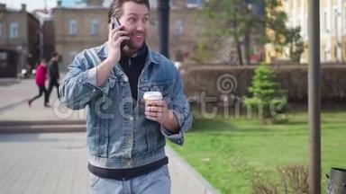 有魅力的人在市中心散步。 会说话的电话。 在上面输入信息。 喝着美味的咖啡。 一个人走进来