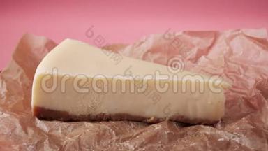 在食品包装纸上丢失一片新鲜的传统奶酪蛋糕。 框架。 孤立于粉红色
