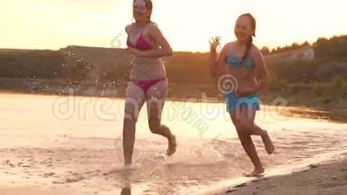 女孩们在沙滩上<strong>奔跑</strong>，在海滩上溅起水滴，笑着。 快乐自由<strong>的</strong>青<strong>少年</strong>