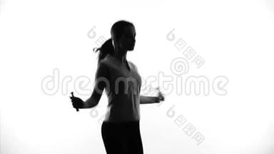自信的女人跳绳减肥，锻炼和运动，剪影
