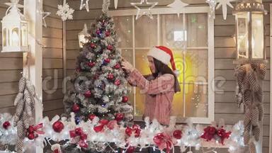 小女孩用红球装饰圣诞树在斯洛莫的门廊
