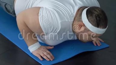 胖子摔倒在瑜伽垫上试图做木板<strong>运动</strong>，<strong>缺乏</strong>能量