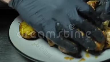 黑手套厨师用现成的什什烤串，放在盘子里，放着蔬菜，形成菜肴