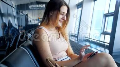 4k<strong>视频</strong>：美丽微笑的年轻女子，在国际机场等待航班时使用智能手机和<strong>打字</strong>信息