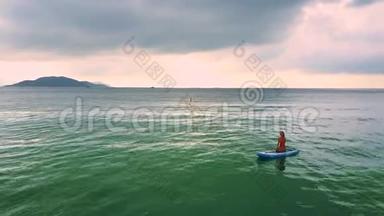 <strong>靠岸</strong>的女孩坐在海边的桨板上