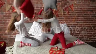 穿着睡衣的三胞姐妹用枕头安排了<strong>打斗</strong>。 卧室装饰着圣诞花环和圣诞节