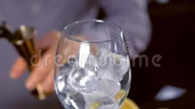 酒保把酒从装有间歇泉的瓶子里倒入跳汰机，然后把它加到冰的酒杯里。 双手特写
