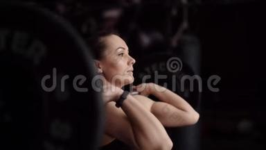强壮肌肉的女人在健身房里表现得很干净，动作也很慢
