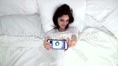 在床上拍手机的美女