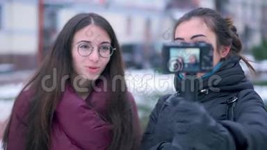 两位深黑肤色的女孩朋友和博客作者在冬季旅行时用相机录制视频