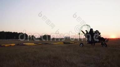 机动滑翔伞与一个女孩和一个男人在机场起飞，加速和起飞的天空降落伞。