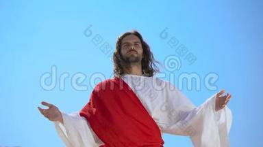 穿长袍的圣人举起双手向天空祈祷灵魂的救赎，复活