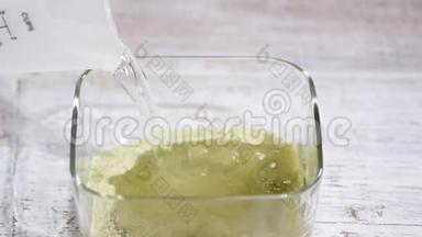 浇热水.. 做绿色果冻。 在玻璃碗里搅拌果冻。