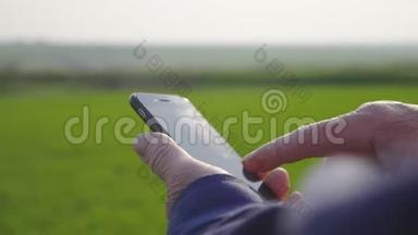 农学家成熟的人在农业农场使用智能<strong>手机</strong>。 把手里<strong>拿</strong>着<strong>手机</strong>的农民关在田里。