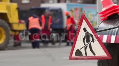 街道上的道路工程标志。 道路上的道路工程标志。 工人铺设新沥青