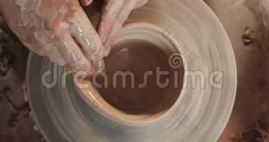 陶工在扭曲的陶轮上制作陶瓷锅.. 上景。 波特在工作，<strong>关门</strong>。 <strong>手</strong>工制作，工艺.. 白色粘土