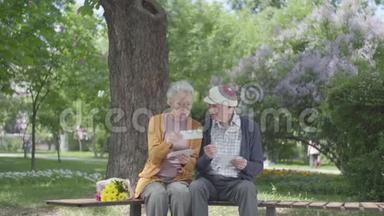 肖像可爱的<strong>成</strong>年夫妇看着老<strong>照片</strong>，回忆着坐在公园长凳上的快乐时刻。 <strong>成</strong>熟<strong>成</strong>熟