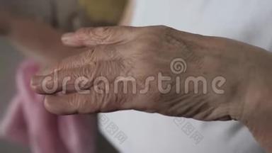 一位老妇人颤抖着颤抖着手的特写镜头