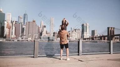 快乐的白种人男人抱着他的女朋友在纽约著名的布鲁克林桥景观慢动作微笑。