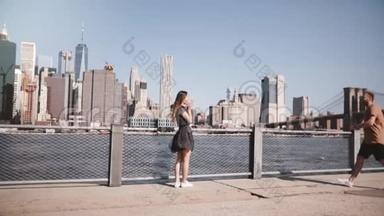 快乐的欧洲女孩遇见她的男朋友，拥抱和交谈在阳光明媚的曼哈顿景色在纽约市慢动作。