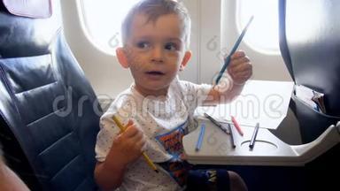 4k小男孩在<strong>飞机</strong>上长时间飞行时用铅笔<strong>画画</strong>的视频