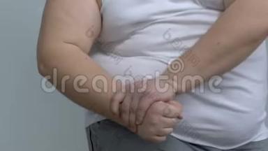 肥胖的单身汉展示手臂肌肉，假装肌肉发达，<strong>缺乏运动</strong>
