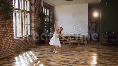 穿着白色芭蕾舞裙的年轻优雅的芭蕾舞演员在舞厅里表演古典舞。 白色美丽的纤细芭蕾舞女演员