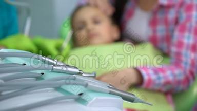 小男孩害怕牙钻治疗，母亲抚慰孩子，背景