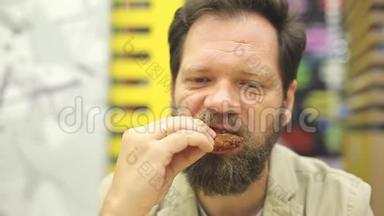 一个留胡子的白种人在快餐店吃炸鸡翅和<strong>金块</strong>。