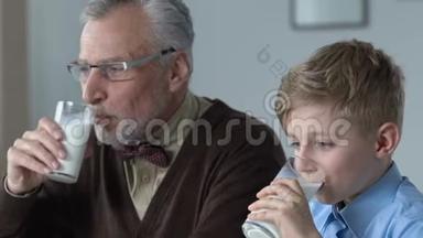 小学生和爷爷早上一起喝牛奶，家庭早餐