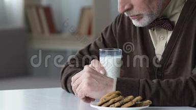 伤心的老人坐在桌旁不肯喝牛奶，在养老院不开心
