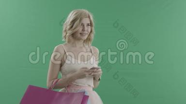 有智能手机和包包的漂亮女人用绿色屏幕问候某人