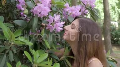 一个年轻漂亮的女人闻着朵朵紫花