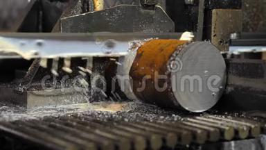用冷却剂切割钢棒的工业机器。 带锯用于用冷却剂切割原始金属。
