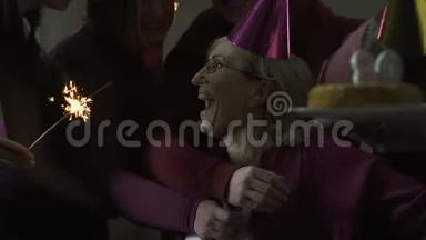 朋友和家人在她80岁生日聚会上拥抱幸福的女人，庆祝