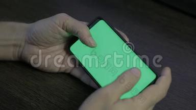 使用绿色<strong>屏幕</strong>的智能手机。 手<strong>滚动</strong>页面，点击触摸屏。 上面的风景。 铬钥匙。