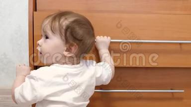 <strong>小孩</strong>子，学会<strong>走路</strong>，拿着壁橱的把手，在儿童室。