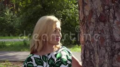 有魅力的女人用手触摸松树的树皮，四处走动