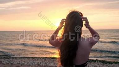 穿黑色泳衣的时髦女孩在日落时进入<strong>大海</strong>。 我对<strong>大海</strong>和海滩很满意。 关于